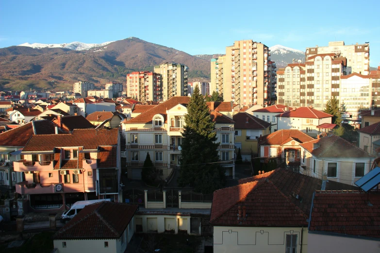 a row of buildings near large mountain on a clear day