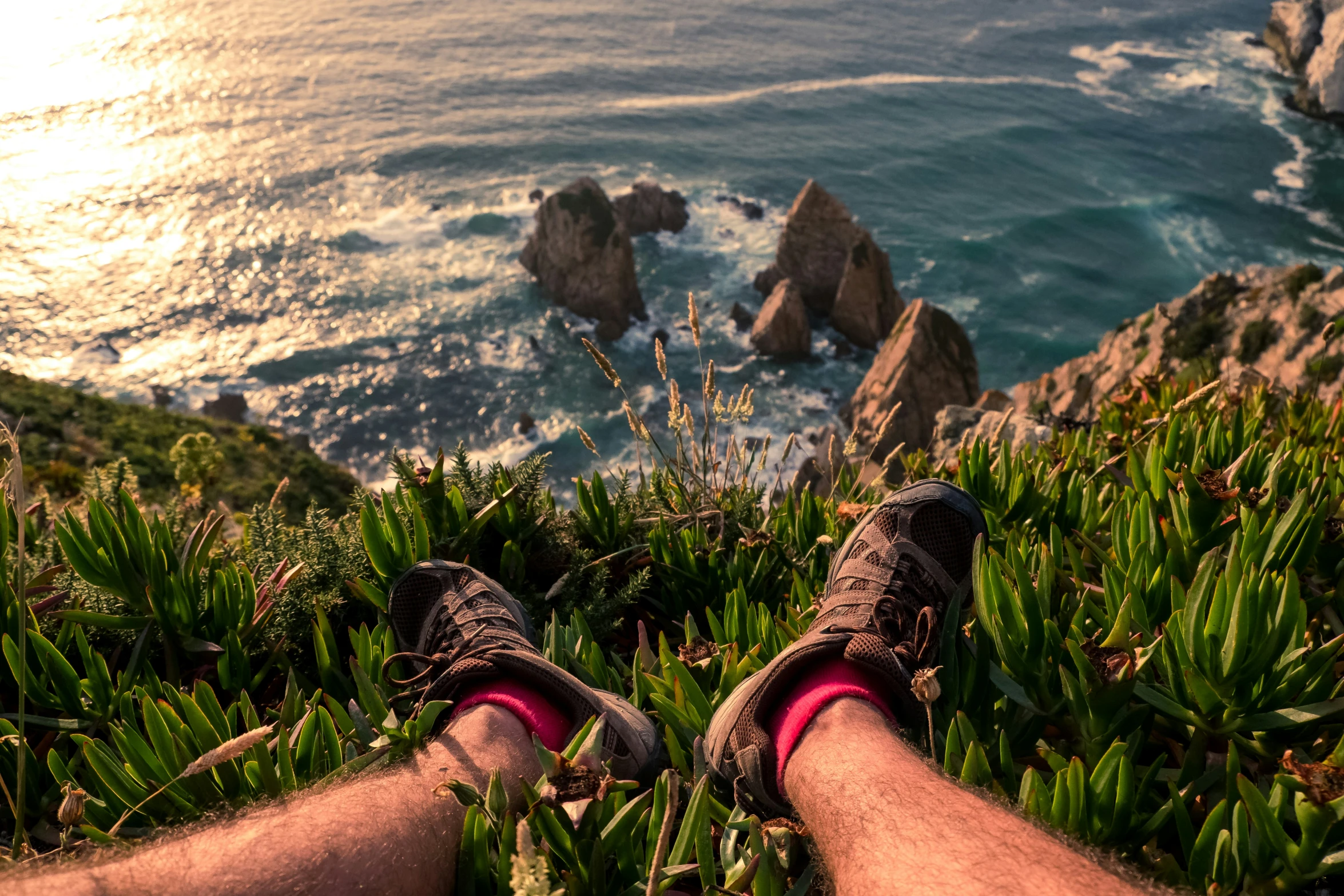 someone has their feet propped on the edge of grass looking down