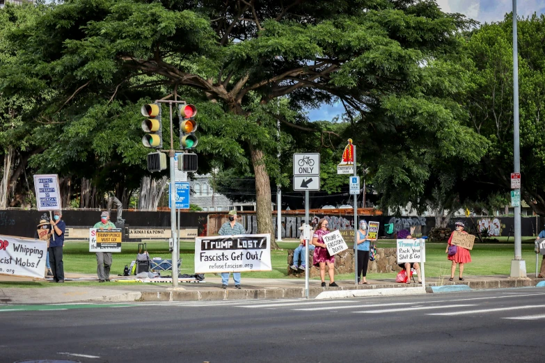 some people stand behind a sign in the street