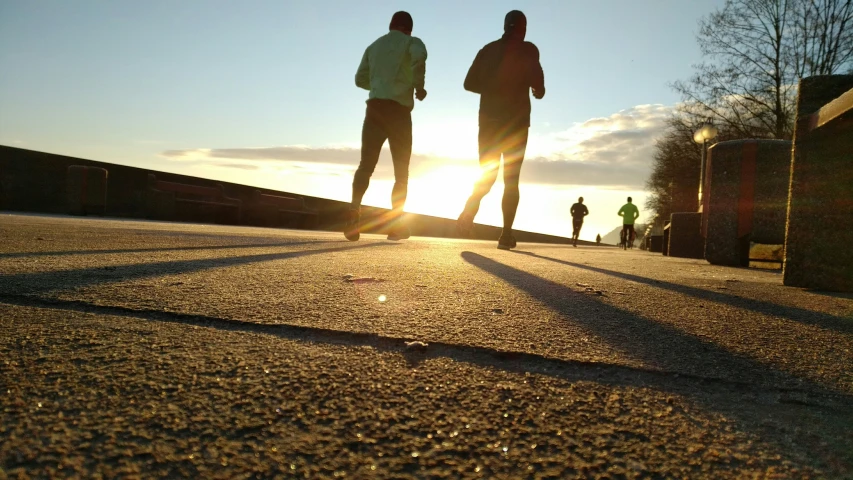 the silhouette of two people walking down a road