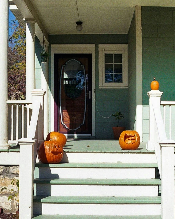 the front steps of a house with pumpkins carved on it