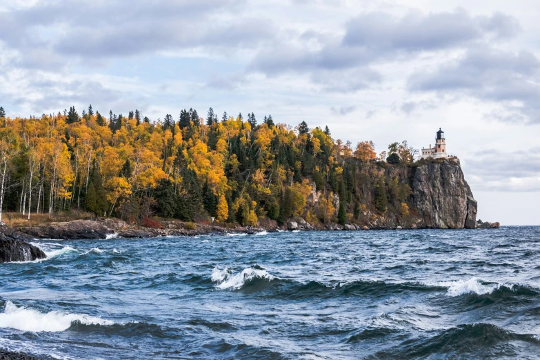 an island sits along the edge of a lake with an island in the background