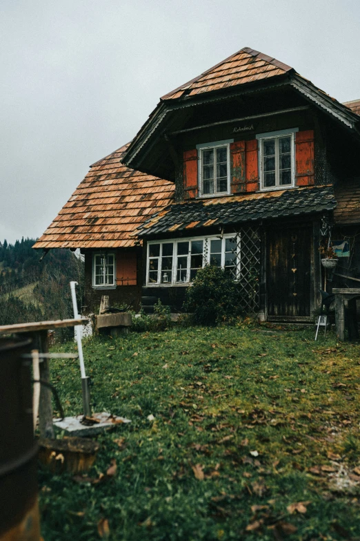 a house with red shutters and a brown roof