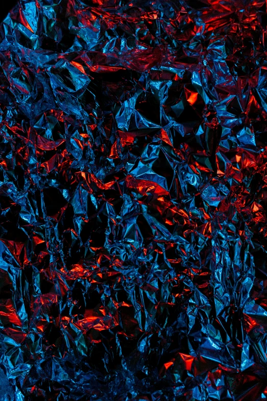 blue and red colored crystals are scattered over a black background