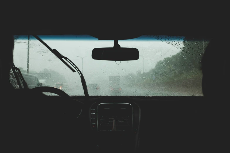 a dirty windshield and some buildings near by