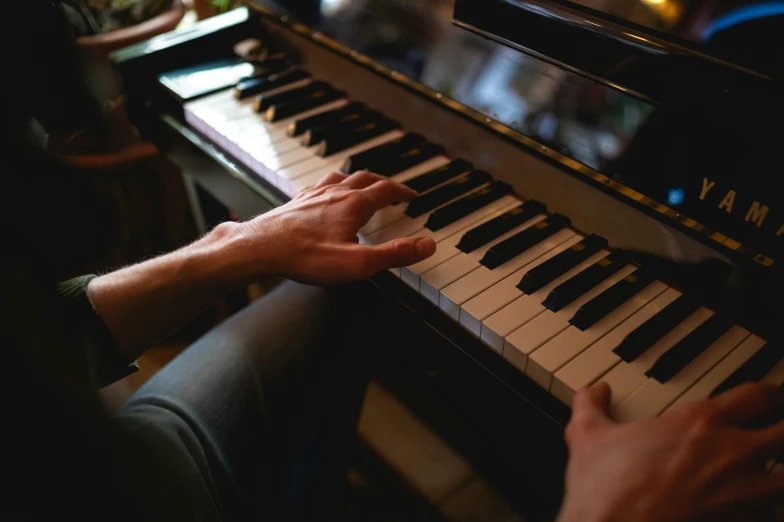 a person sitting at a piano playing the music