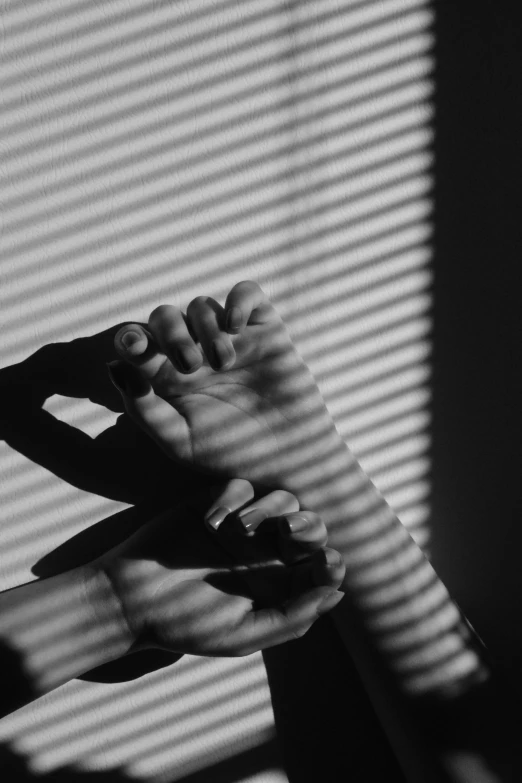 two hands holding each other near blinds
