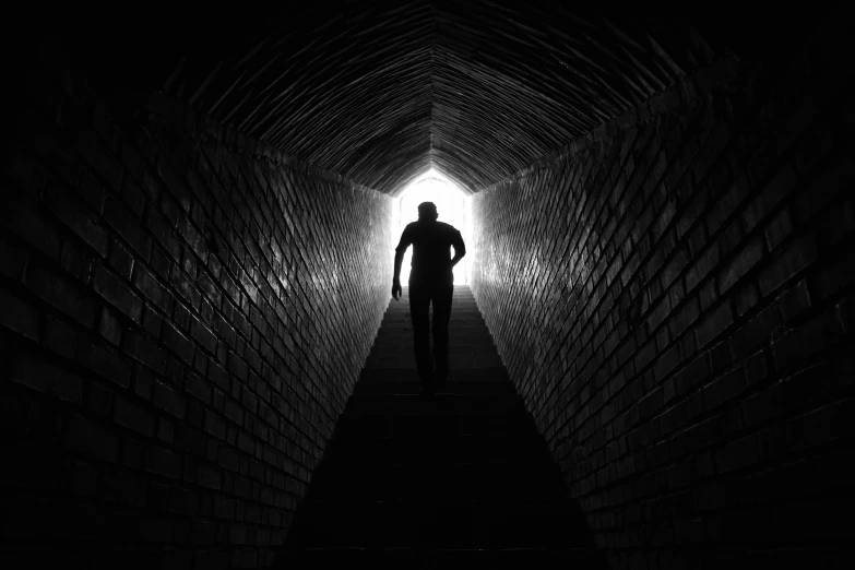 a person walking through a tunnel in the dark