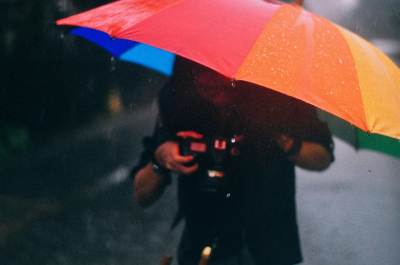 a person holding an open umbrella on the sidewalk