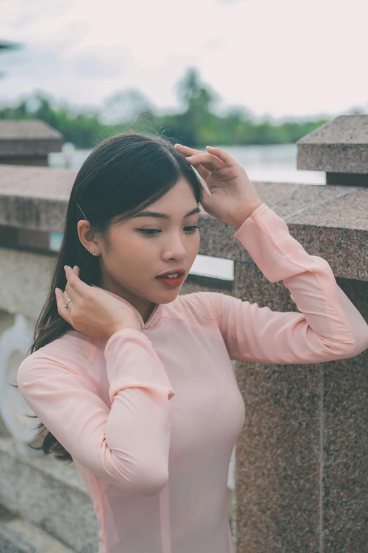 an attractive woman holding her hair looking into the distance