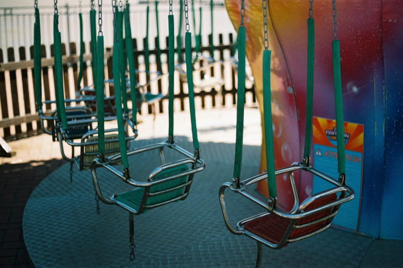 colorfully painted swings and chairs in a children's playground