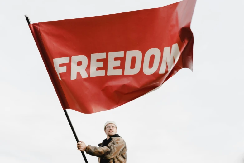 a person holding a flag with the word'freedom '