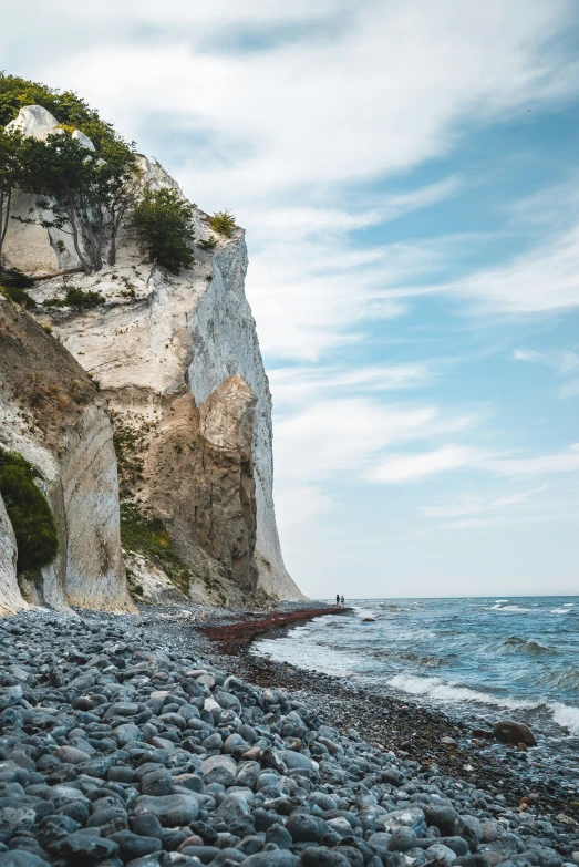 an empty boat on the rocky beach near a cliff