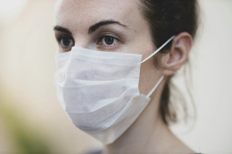 a woman wears a face mask to protect her from the effects of blowing up the dust