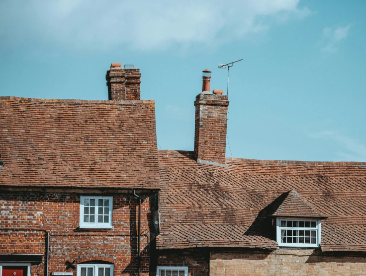 a few roof tops that are brick with two chimneys