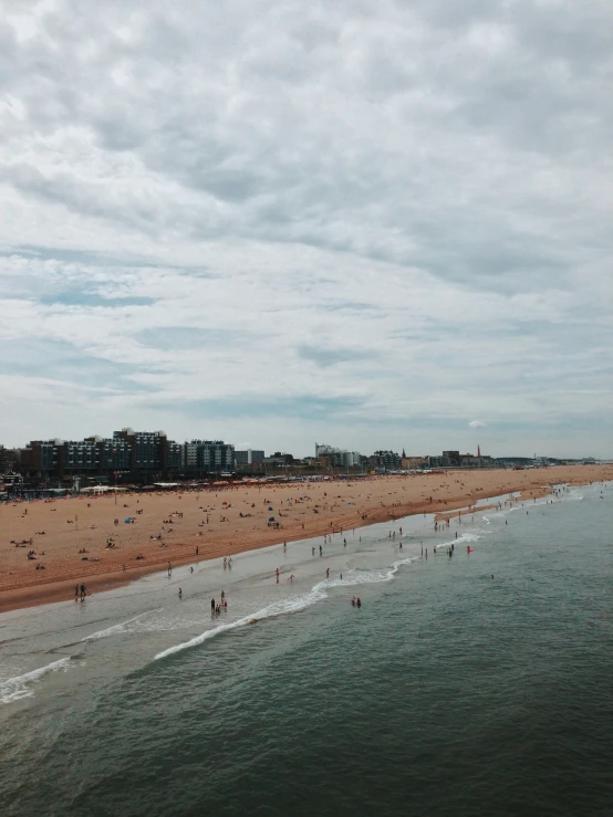 people are enjoying the sun on a busy beach