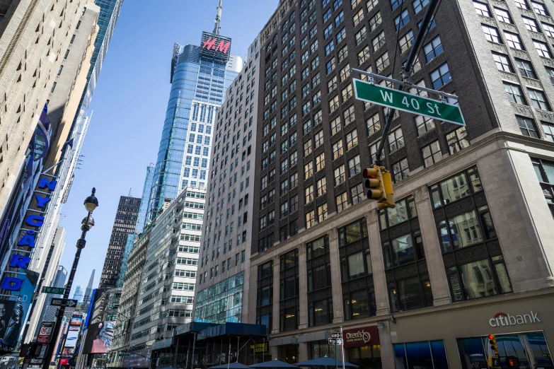 the street has tall skyscrs with cars and traffic lights