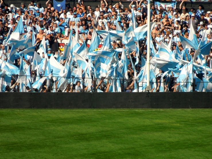 fans and flags on the side of a large stadium