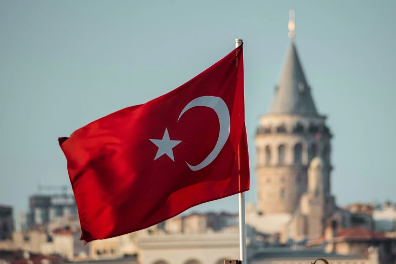 flag and tower of a large building with a city in the background