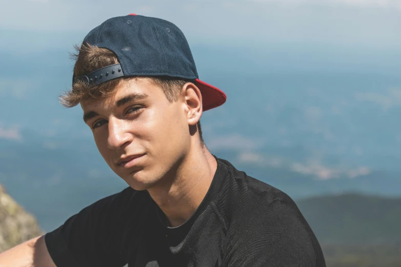 a man is posing for a picture on top of a mountain