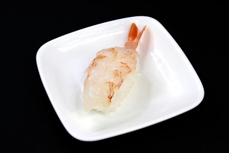a piece of cooked sea food on a square plate
