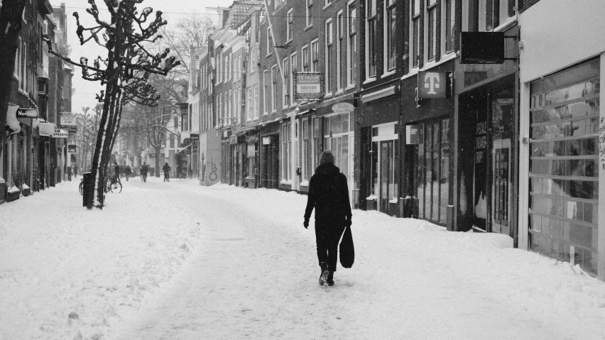 a person walks down a snowy city street