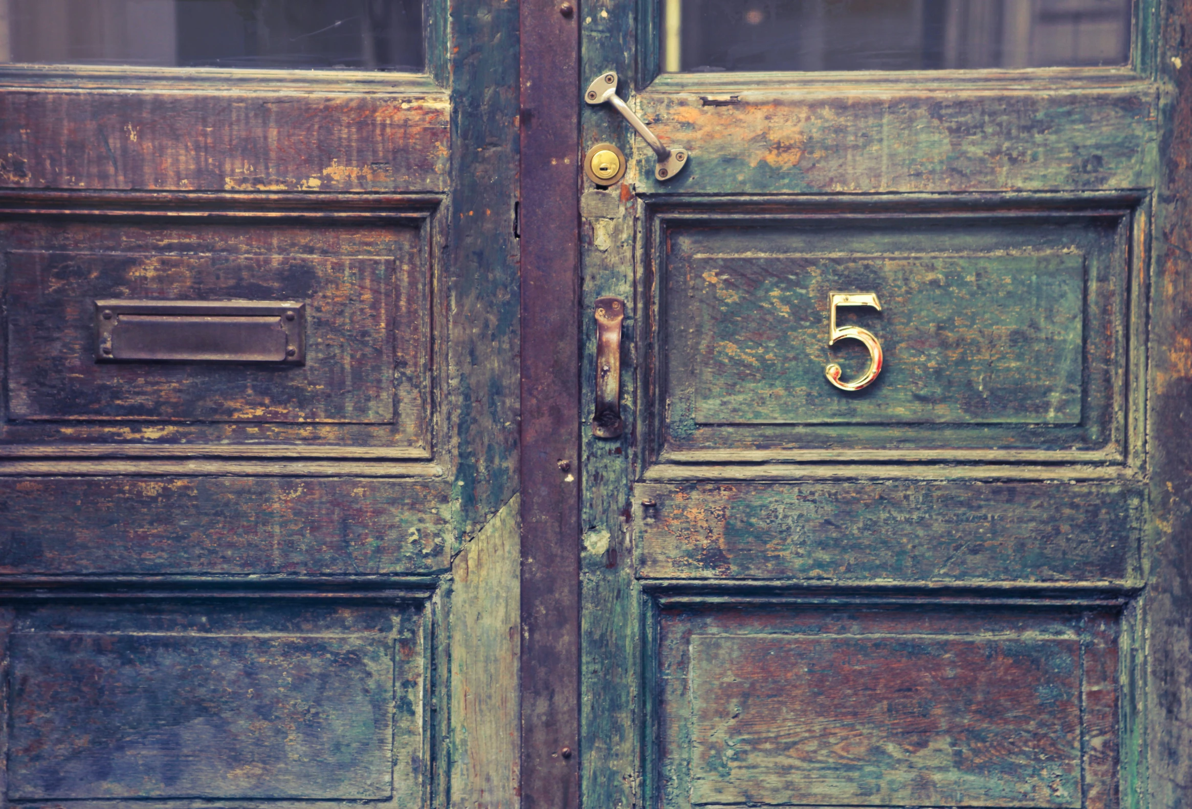 an old door with an interesting number and rust