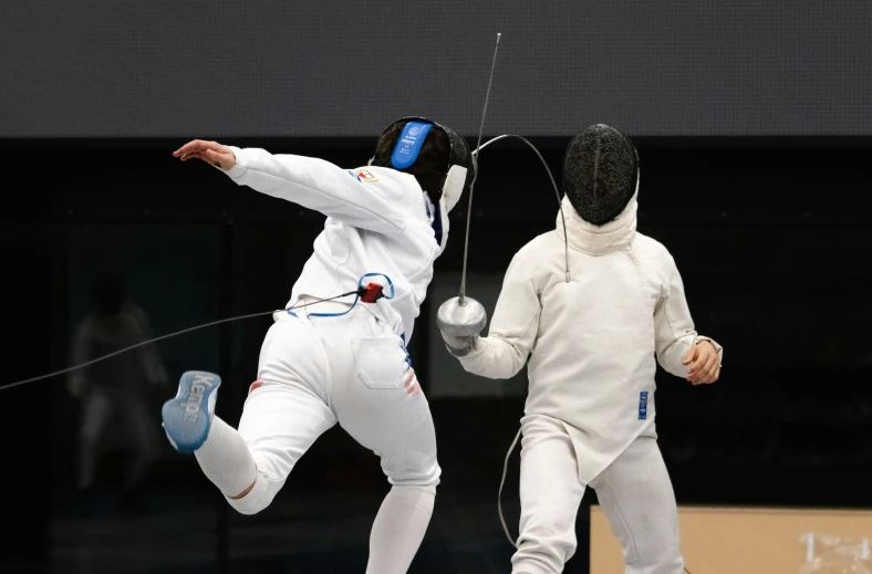 two fencing fencing players in white suits and fencing equipment