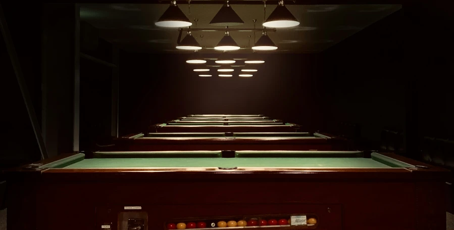 pool tables and lights on a dark room