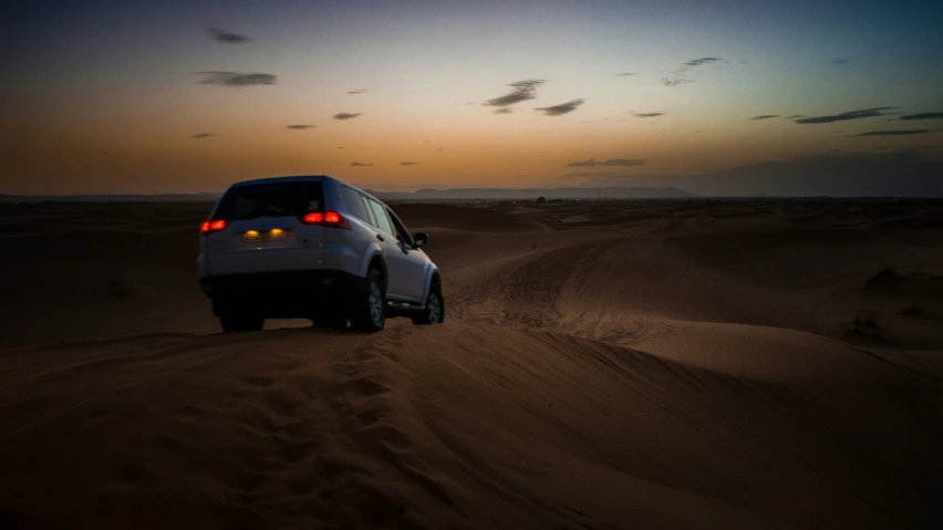 a car driving down the middle of a desert road