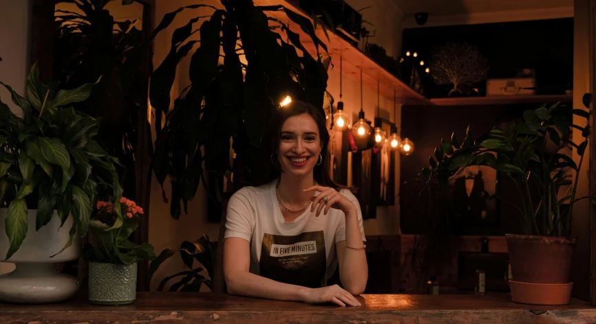 the woman smiles as she sits behind a table in the restaurant