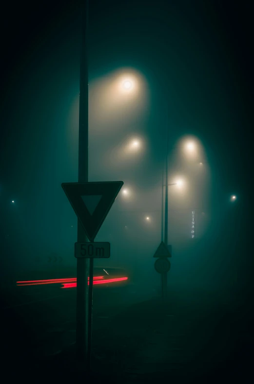 a foggy night with streetlights and signs