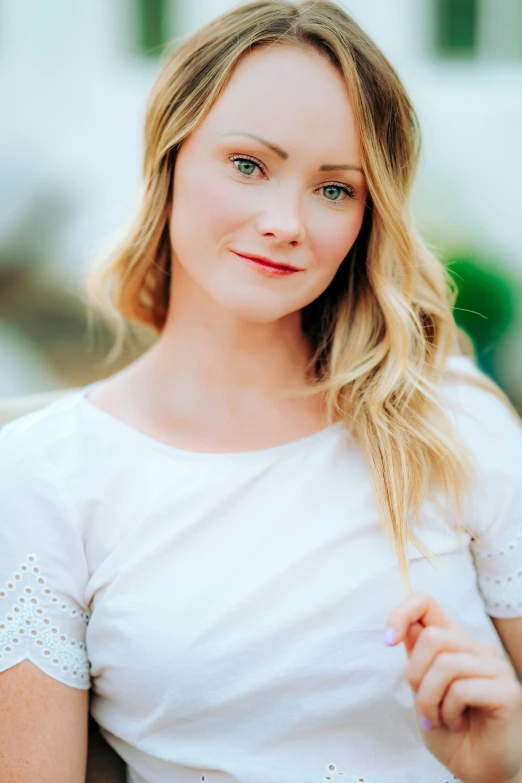 a pretty blonde woman holding her hair in half