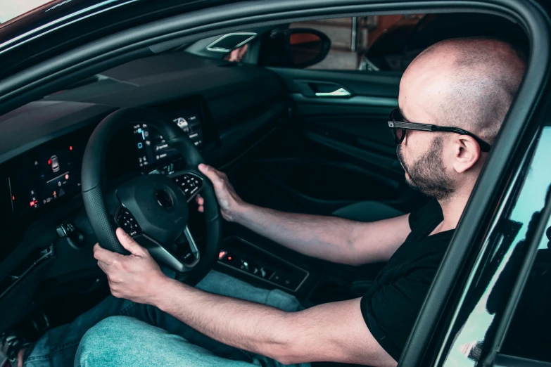 a man wearing black driving in the street