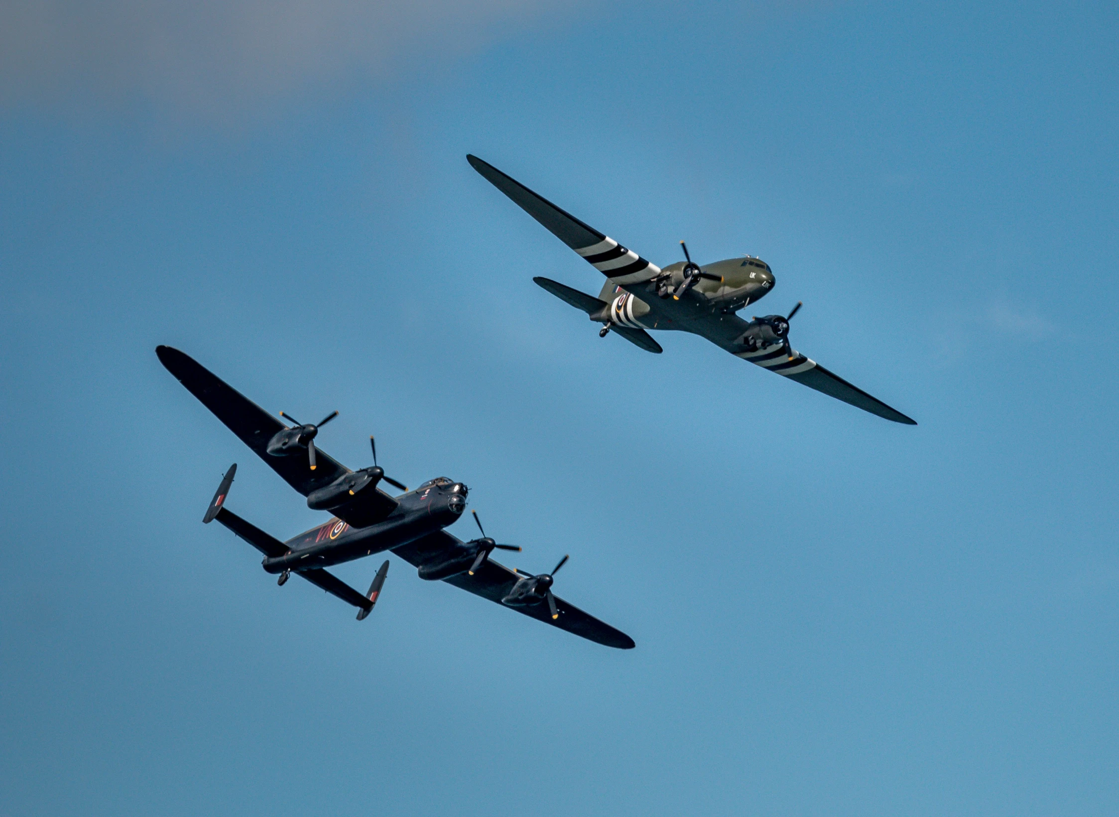 three old fashioned airplanes are flying in the sky