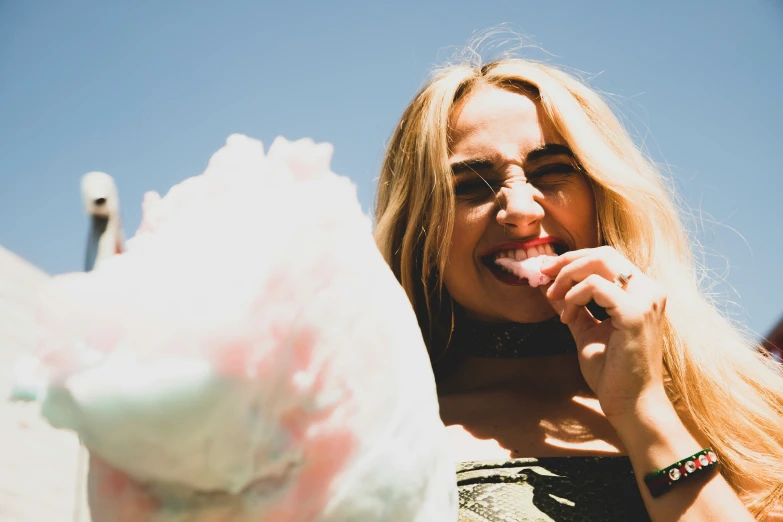 a beautiful young blonde woman holding a large white cake in her hand