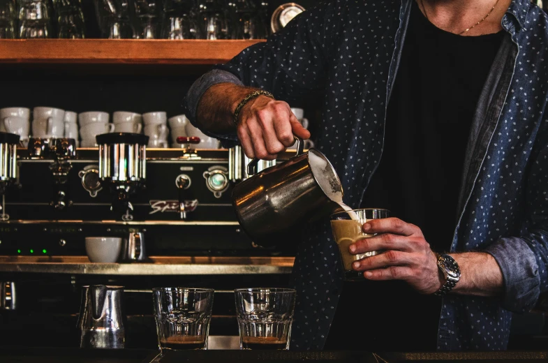 a man pours some kind of drink on the bar