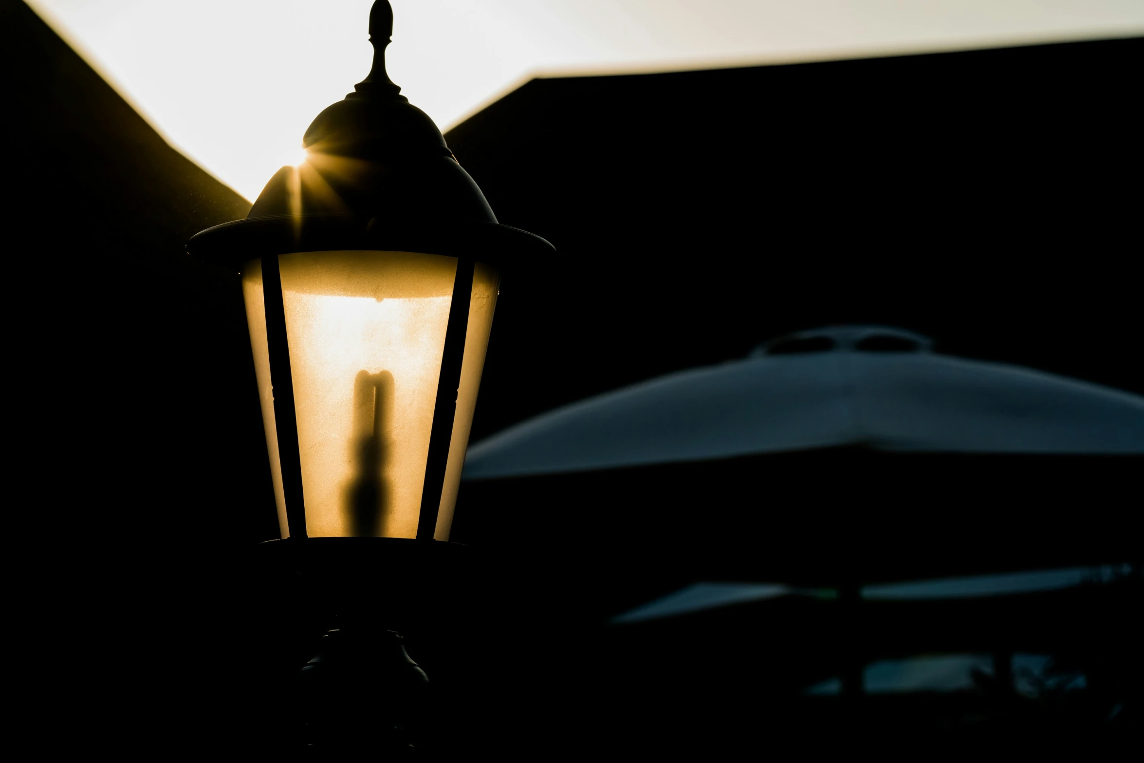 the back light of a lamp with an umbrella in the background