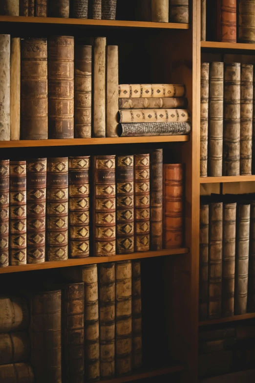 old books are stacked together on a bookcase