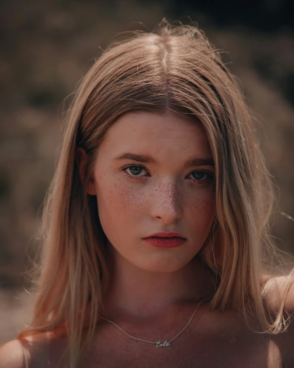 a beautiful blonde woman wearing a silver necklace