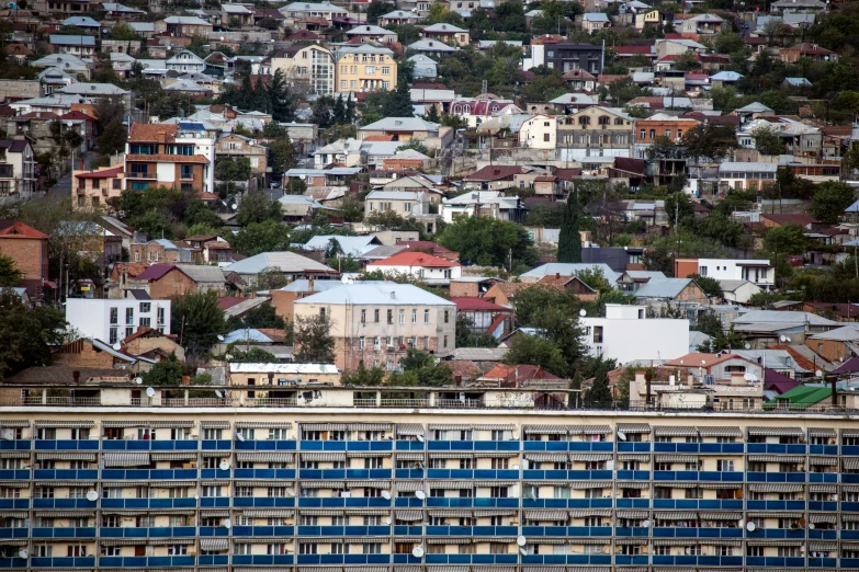 some buildings a tall building and a hill