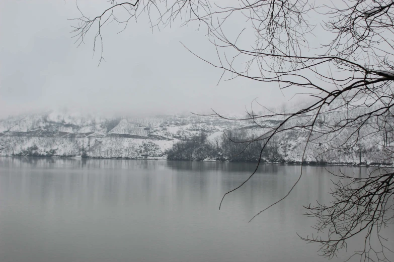 a lake in a snowy and cloudy area