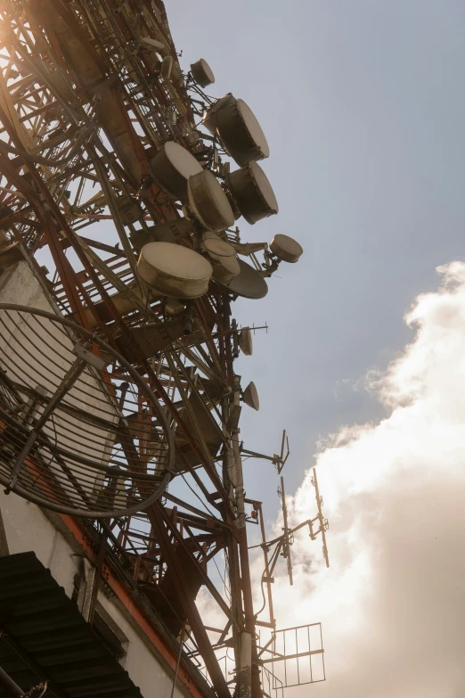 the top portion of a cellular tower in front of the sun