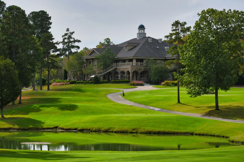 a golf course with a large house and green grass