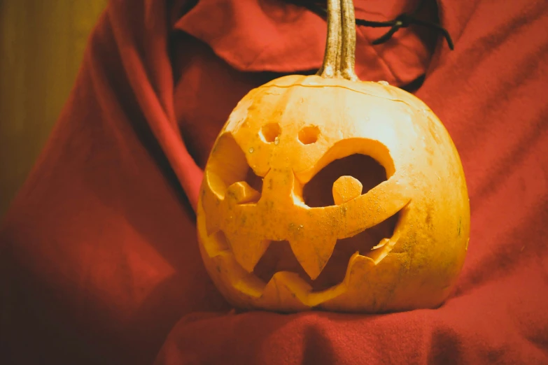 an elaborate carved pumpkin sits with it's face cut out