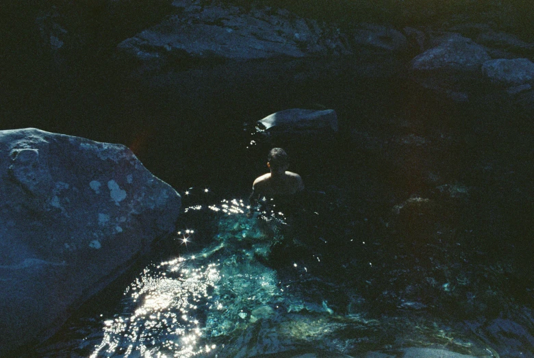 a person on rocks in the middle of water