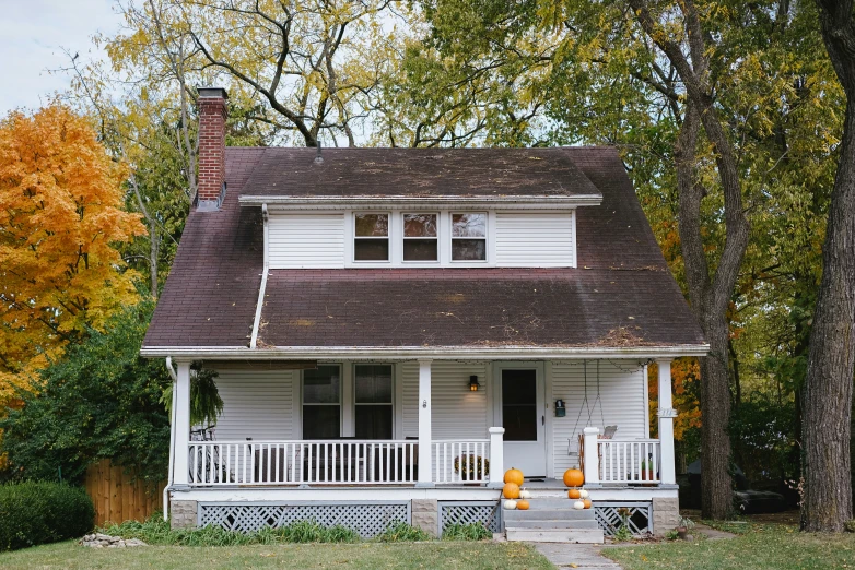 a white house in a tree filled field