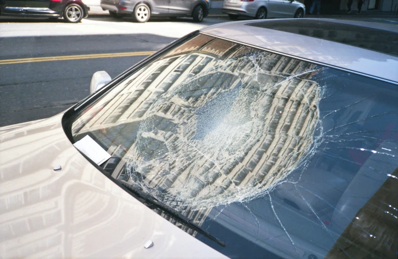 an old broken windshield with bullet holes sitting on it