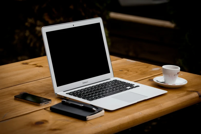 an open laptop computer sitting on top of a wooden desk