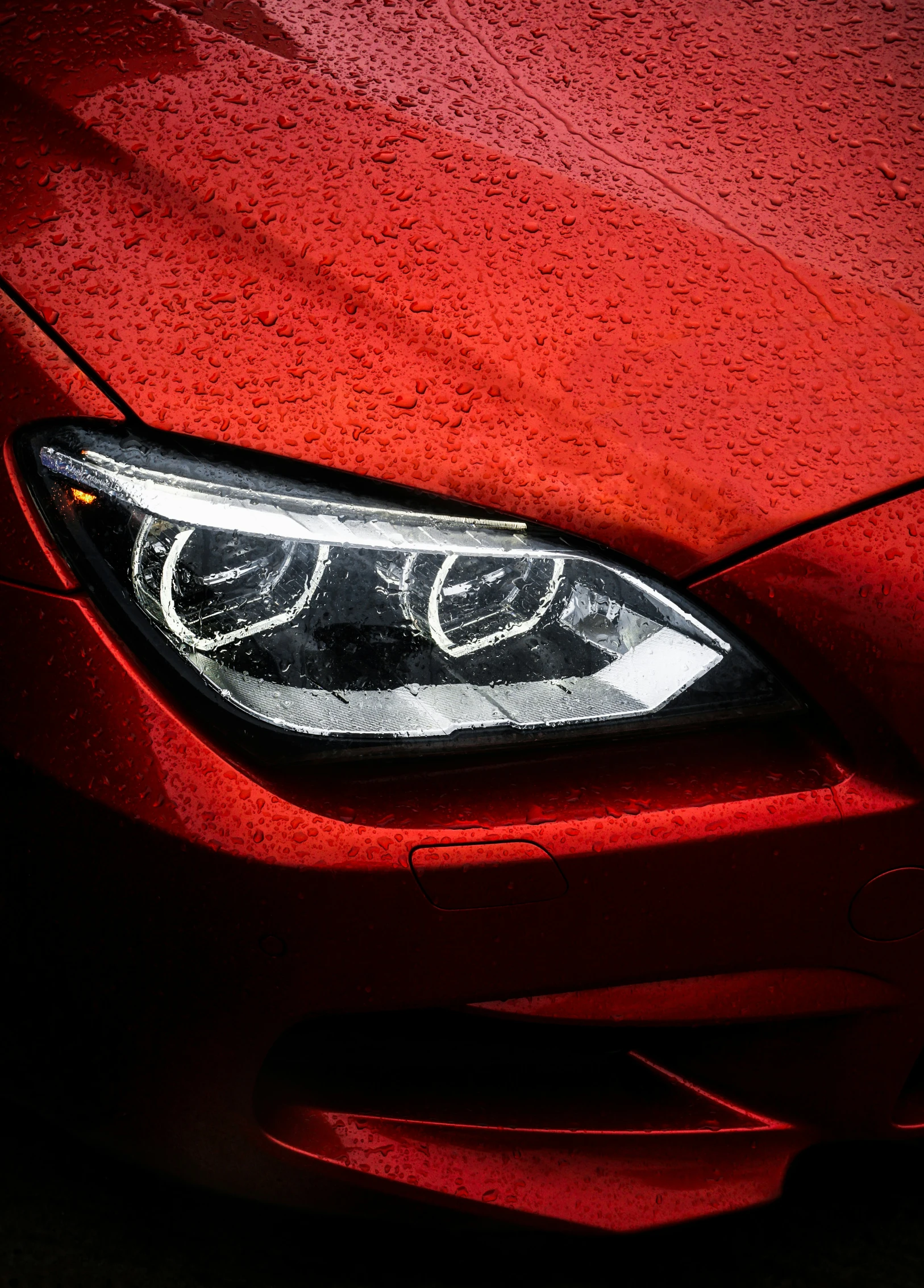 a red bmw is parked on a dark street